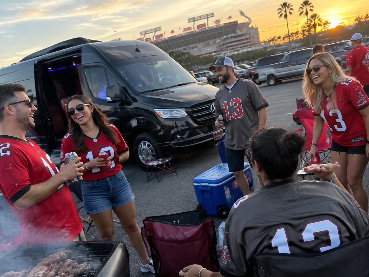 Friends tailgating beside the black Sprinter limo before a Bucs game